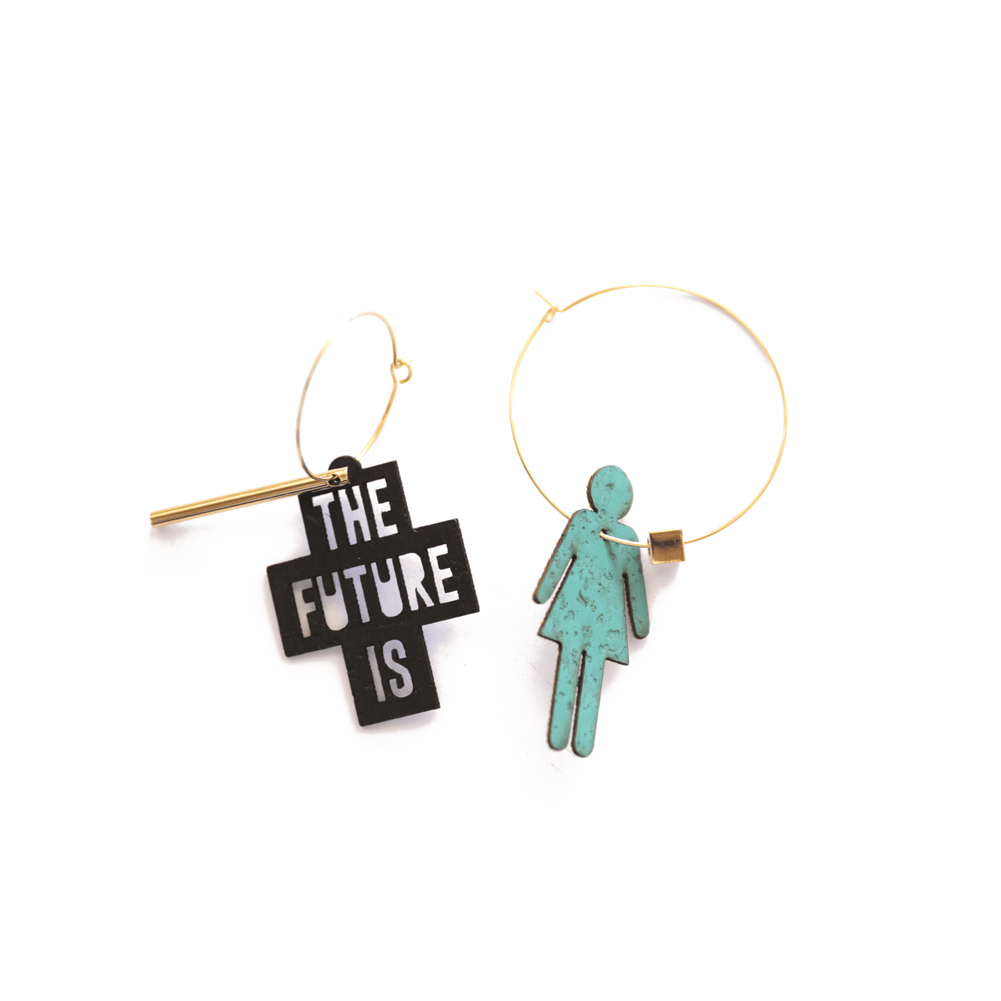 Boucles d’oreilles asymétriques dorées : une créole avec breloque noire portant l’inscription "The Future Is" et une créole assortie avec pendentif turquoise en forme de silhouette féminine. Bijoux féministes personnalisables fabriqués en France.