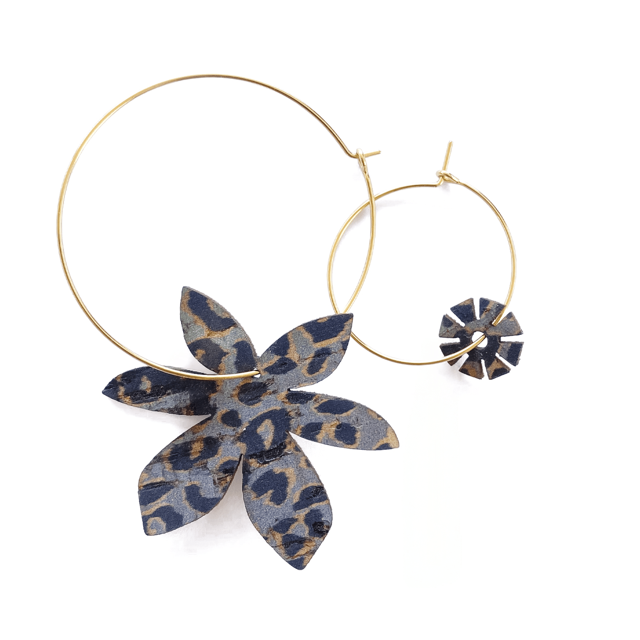 Ces boucles d'oreilles dépareillées Brangelina allient une grande créole dorée ornée d'une fleur en cuir imprimé léopard à une mini créole avec charm floral assorti. Un duo asymétrique audacieux, fabriqué artisanalement en France, pour un style rock et féminin assumé.