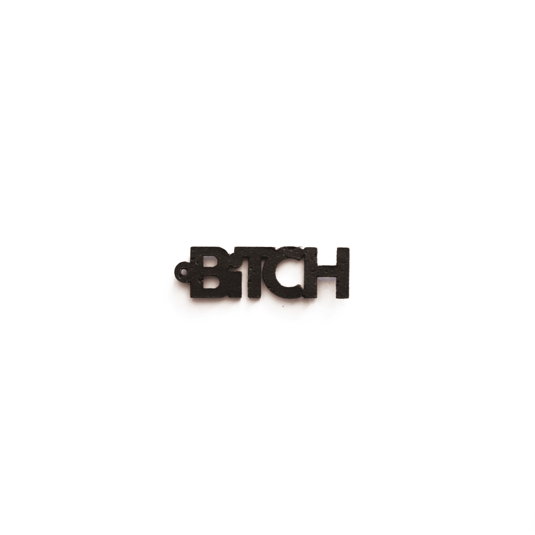 Breloque noire en forme du mot "BITCH", vue de face sur fond blanc, bijou éthique, vegan et personnalisable de la marque Matcha Paris.