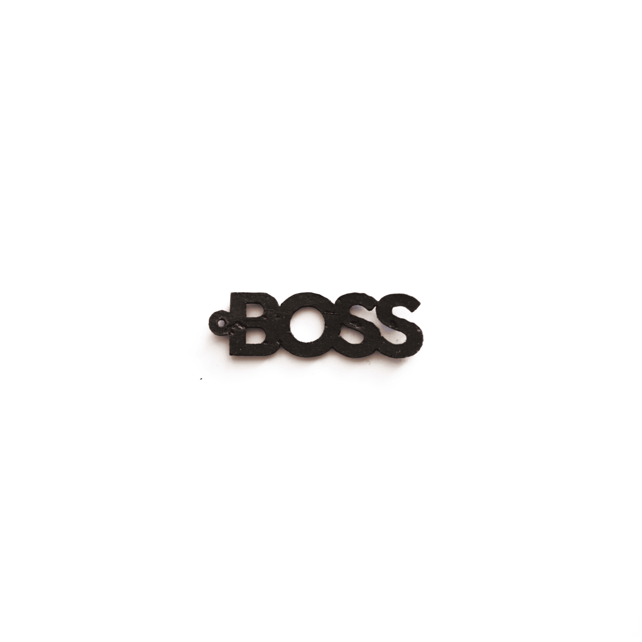 Breloque noire avec le mot "BOSS", en matériau vegan, vue de face sur fond blanc, bijou personnalisable et éthique de la marque Matcha Paris.