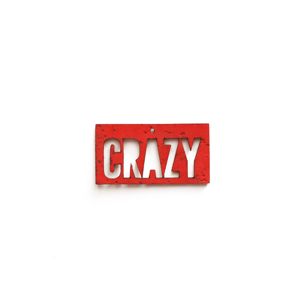 Breloque rectangulaire rouge avec le mot "CRAZY" découpé, en liège vermillon vegan, vue de face sur fond blanc, bijou interchangeable Matcha Paris fabriqué en France.