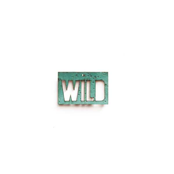 Breloque rectangulaire turquoise avec découpe du mot "WILD", en liège turquoise vegan, vue de face sur fond blanc, bijou éthique et personnalisable Matcha Paris.