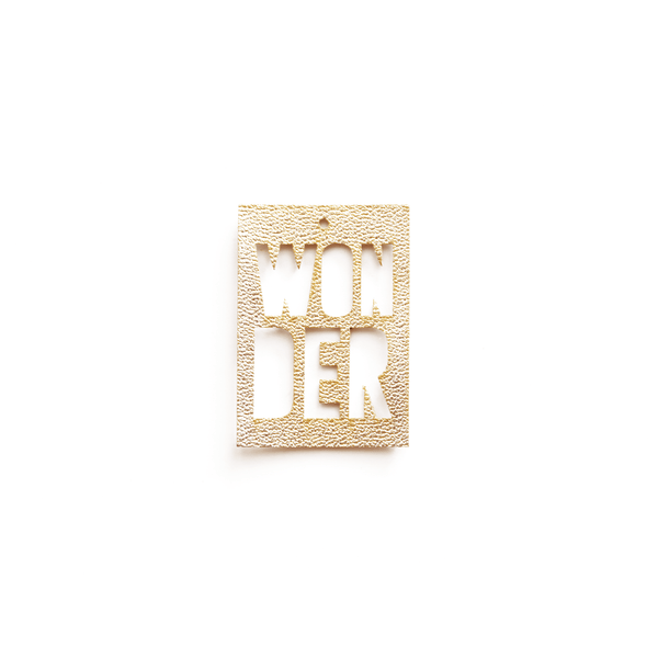 Breloque rectangulaire dorée avec inscription "WONDER", en cuir de maïs vegan, vue de face sur fond blanc, bijou personnalisable fabriqué en France.