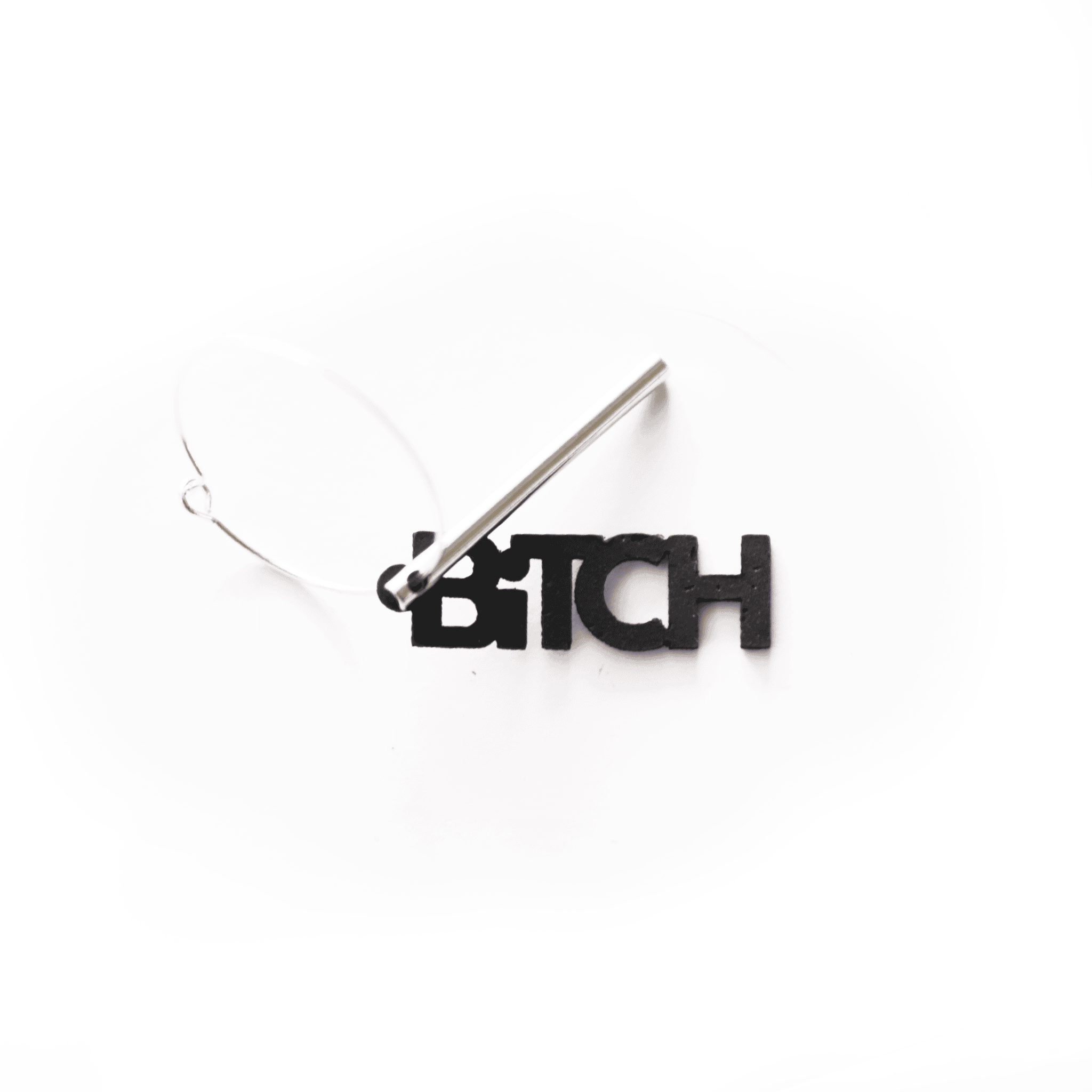 Breloque "BITCH" noire en matériau vegan, bijou interchangeable et fabriqué en France, photographiée sur fond blanc pour la collection Matcha Paris.