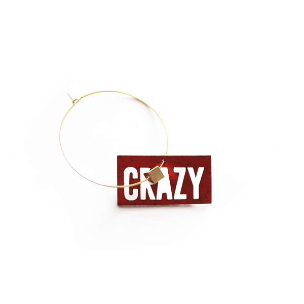 Breloque rouge en liège vegan avec inscription "CRAZY", photographie de détail sur fond blanc, bijou à personnaliser pour créoles Matcha Paris.