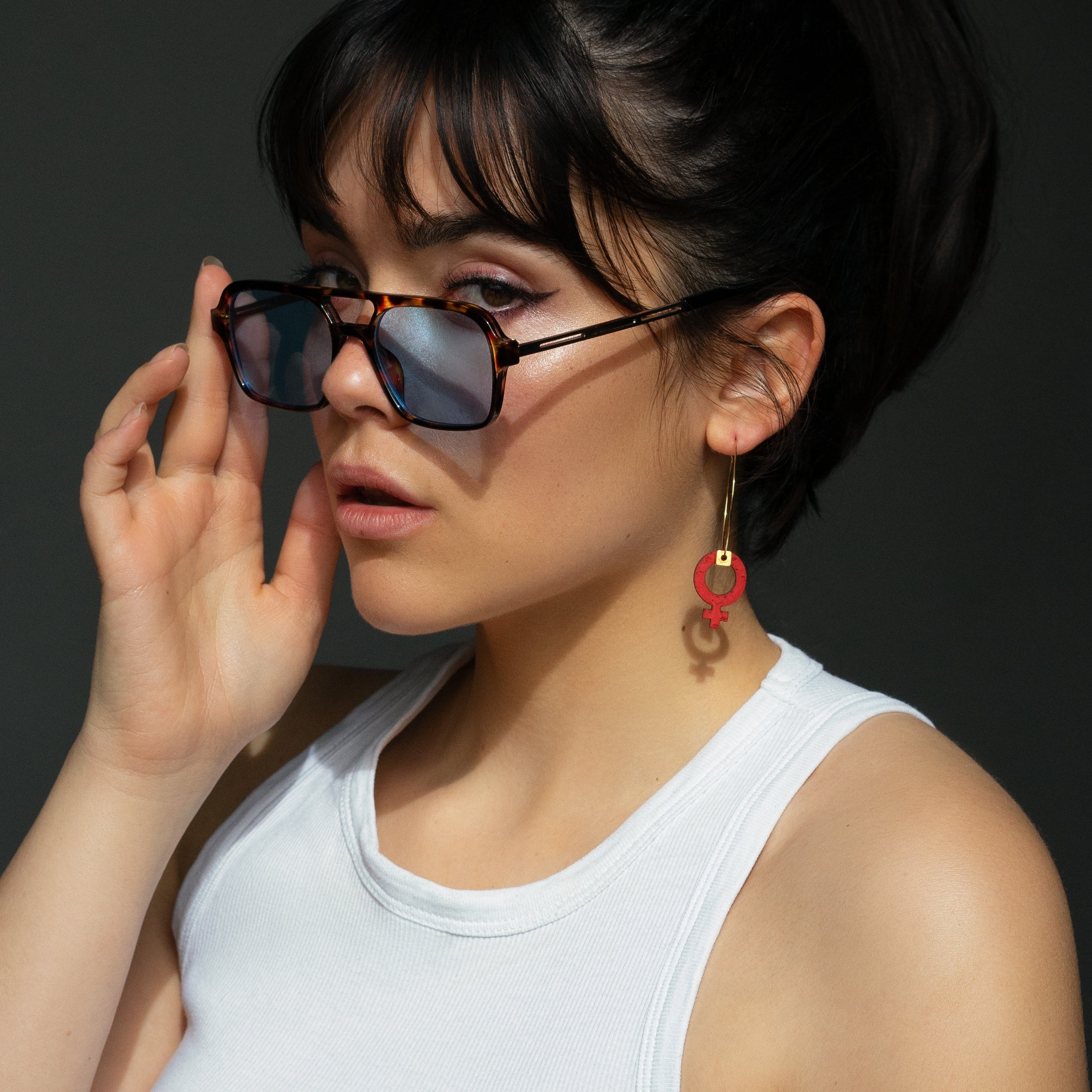 Creole asymetrique GIRL avec breloque feministe rouge, bijou engage porte par une femme, fabrication artisanale Matcha Paris