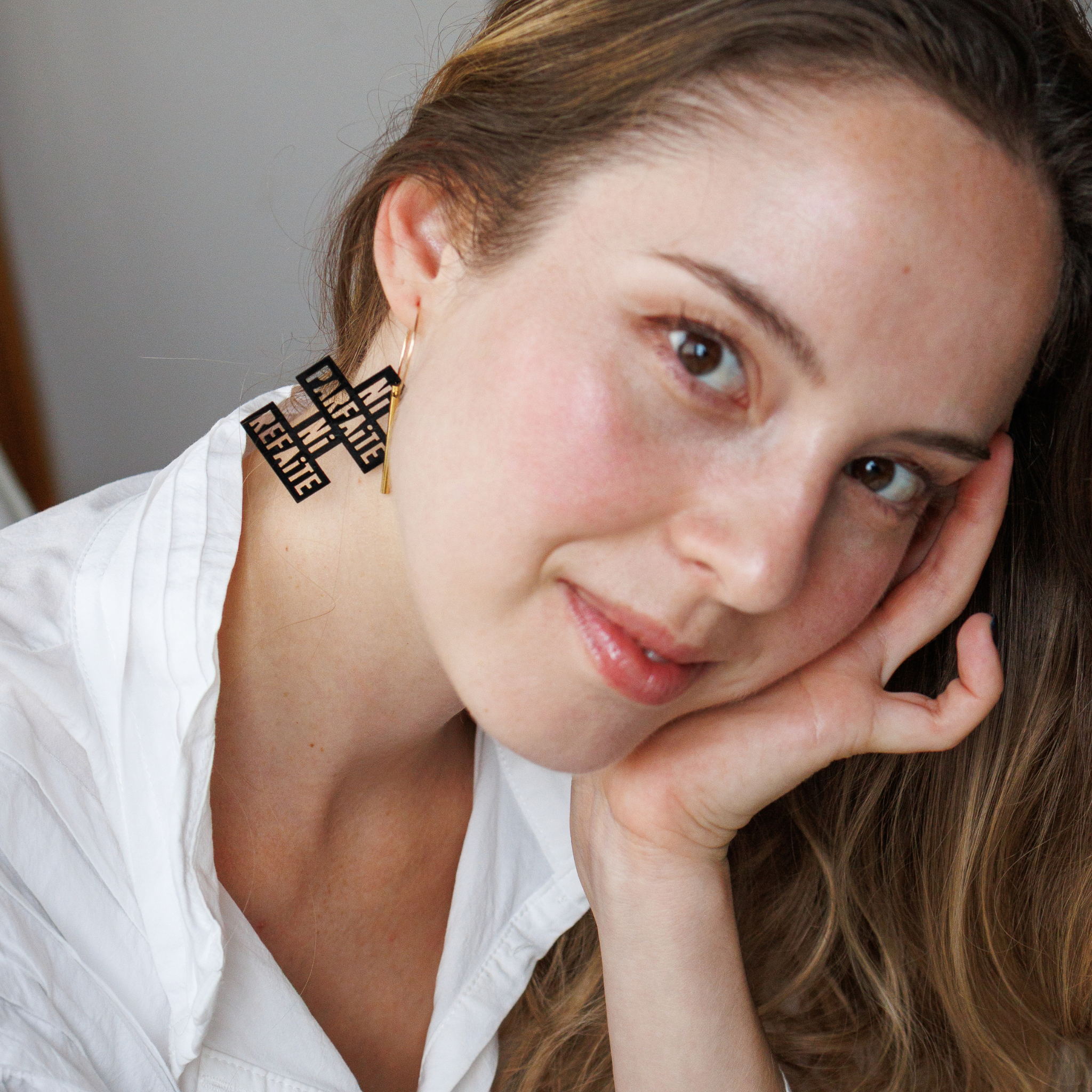 Femme portant les creoles Ni Parfaite Ni Refaite de Matcha Paris, boucles doreilles dorees en matiere recyclee, bijou vegan et fabrique en France.