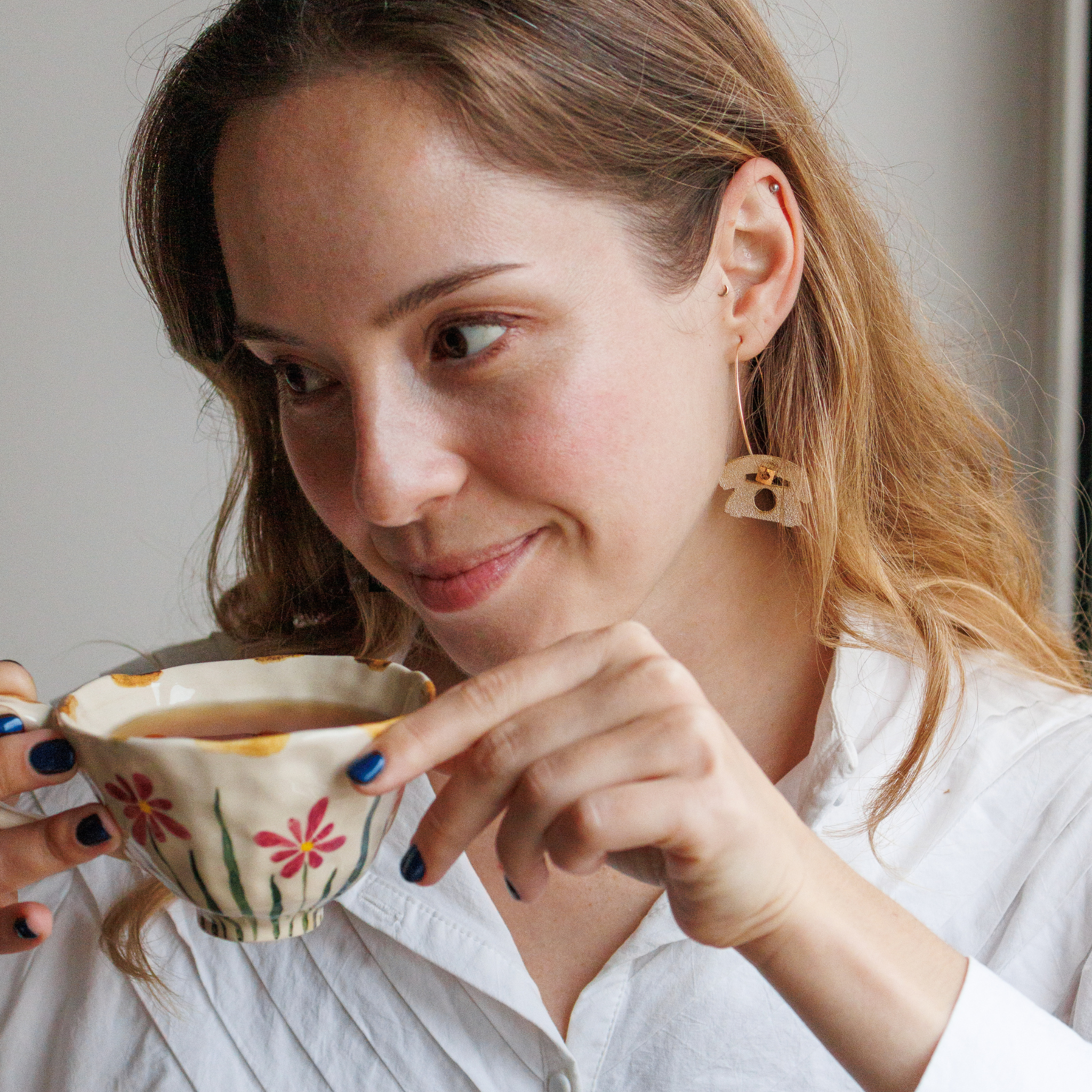 Portrait de femme portant les creoles Stop Checking Your Phone de Matcha Paris, bijoux vegan, durables et fabriques en France.