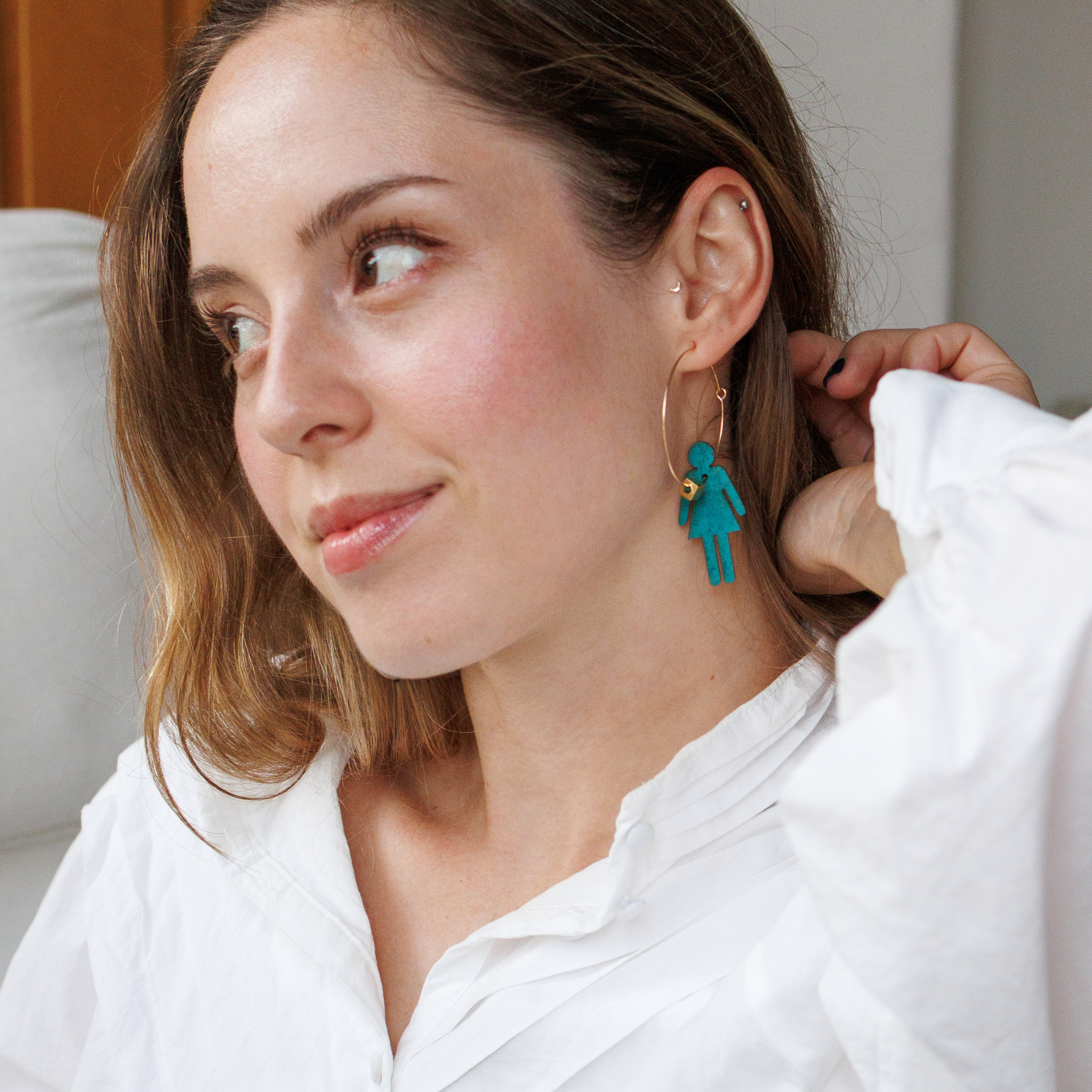 Femme portant les creoles Who Run The World de Matcha Paris, bijoux bleu turquoise pour femmes qui assurent, vegan et fabriques en France.