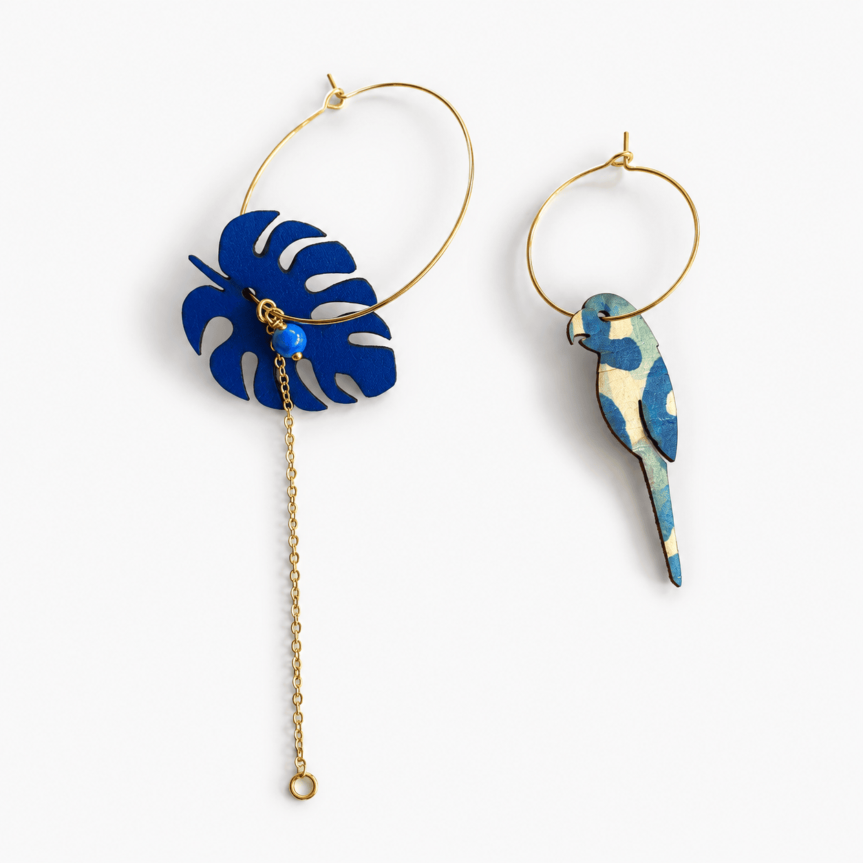 Packshot boucles d'oreilles dépareillées Massalia – créoles dorées monstera et perroquet liège avec chaînette dorée – Matcha Bijoux