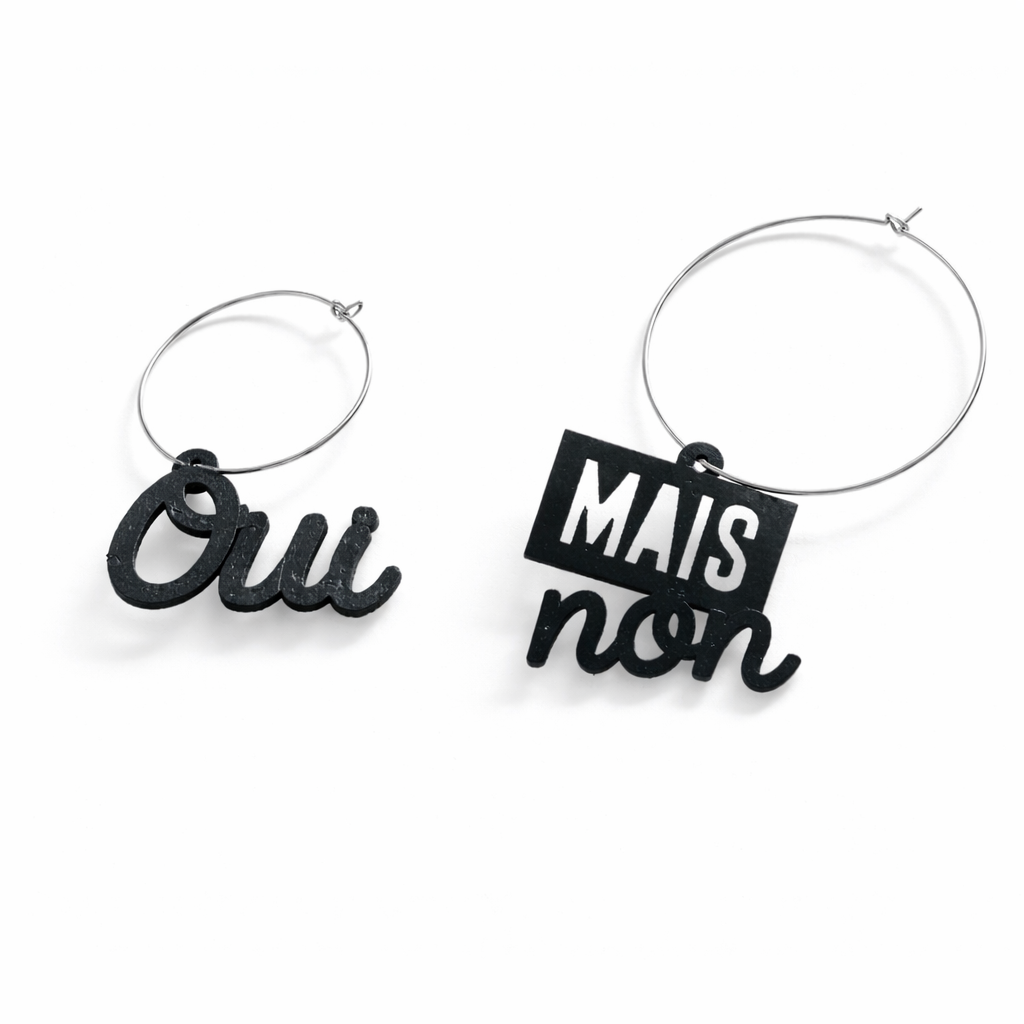 Boucles d oreilles depareillees argent Oui mais non, creoles asymetriques en laiton dore avec message typographique noir, bijou original et engage sur fond blanc.