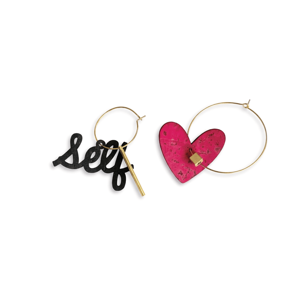 boucles d’oreilles dépareillées self love avec cœur rose et créoles dorées asymétriques en acier inoxydable sur fond blanc