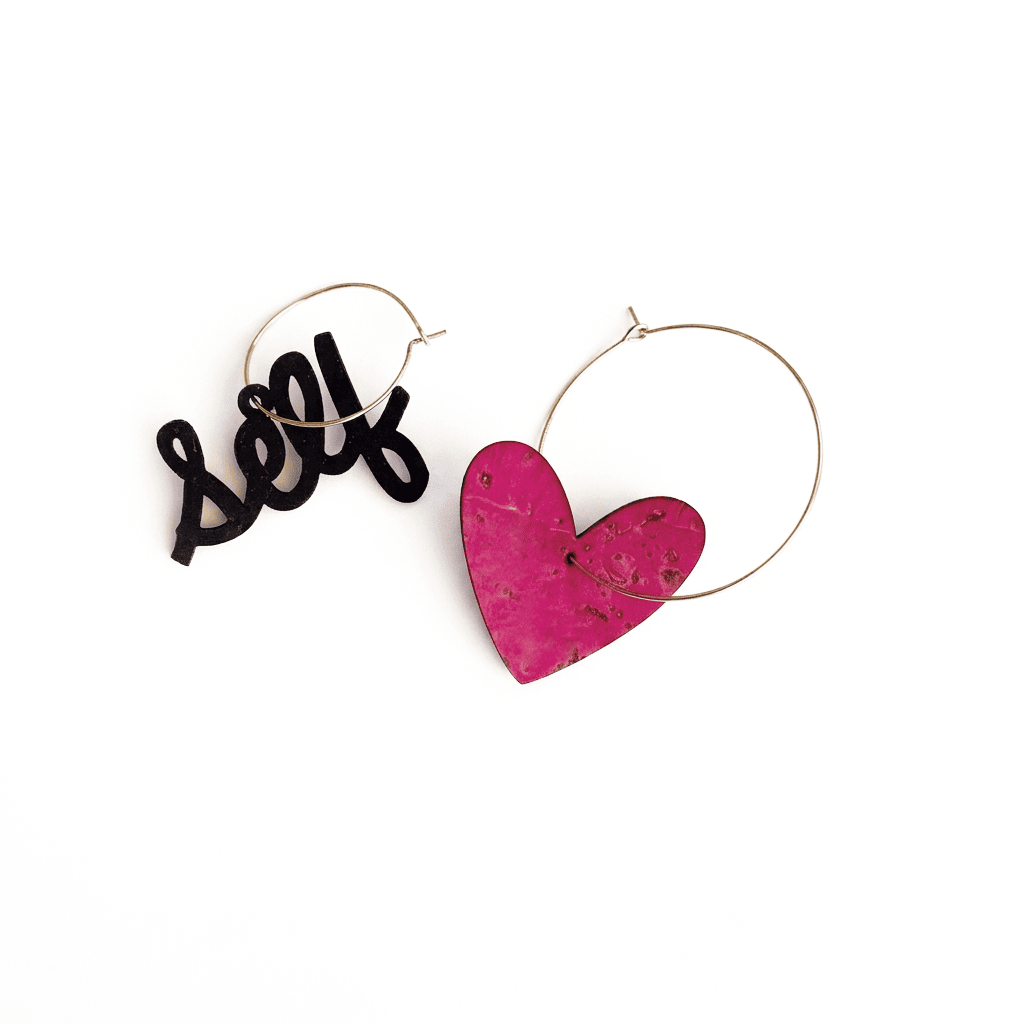 boucles d’oreilles dépareillées self love avec cœur rose et créoles dorées asymétriques en acier inoxydable sur fond blanc