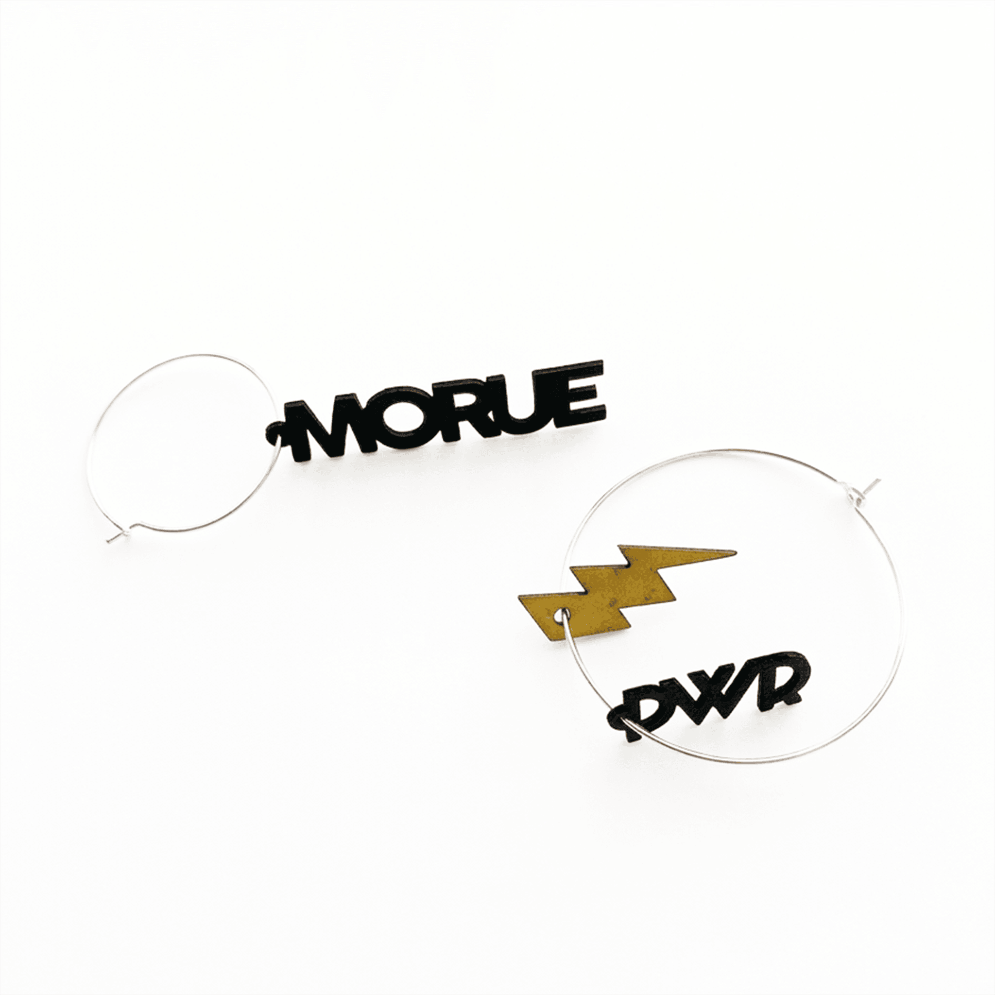 Boucles d'oreilles dépareillées Morue PWR : créoles argent avec pendentifs texte noir et éclair doré, style rock féministe