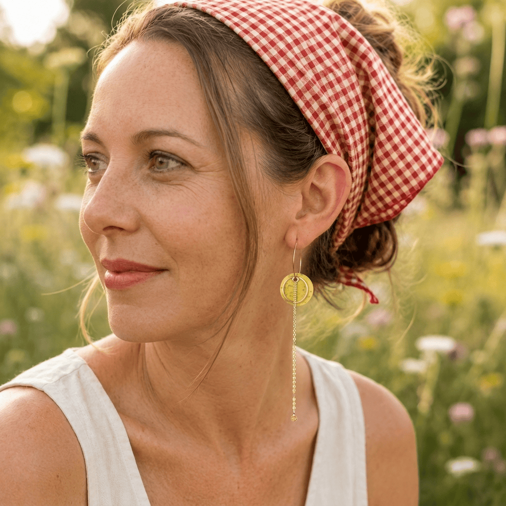 Boucles d'oreilles dépareillées Limon & Cello portées — créole dorée avec rond en liège jaune et longue chainette, faites main en France