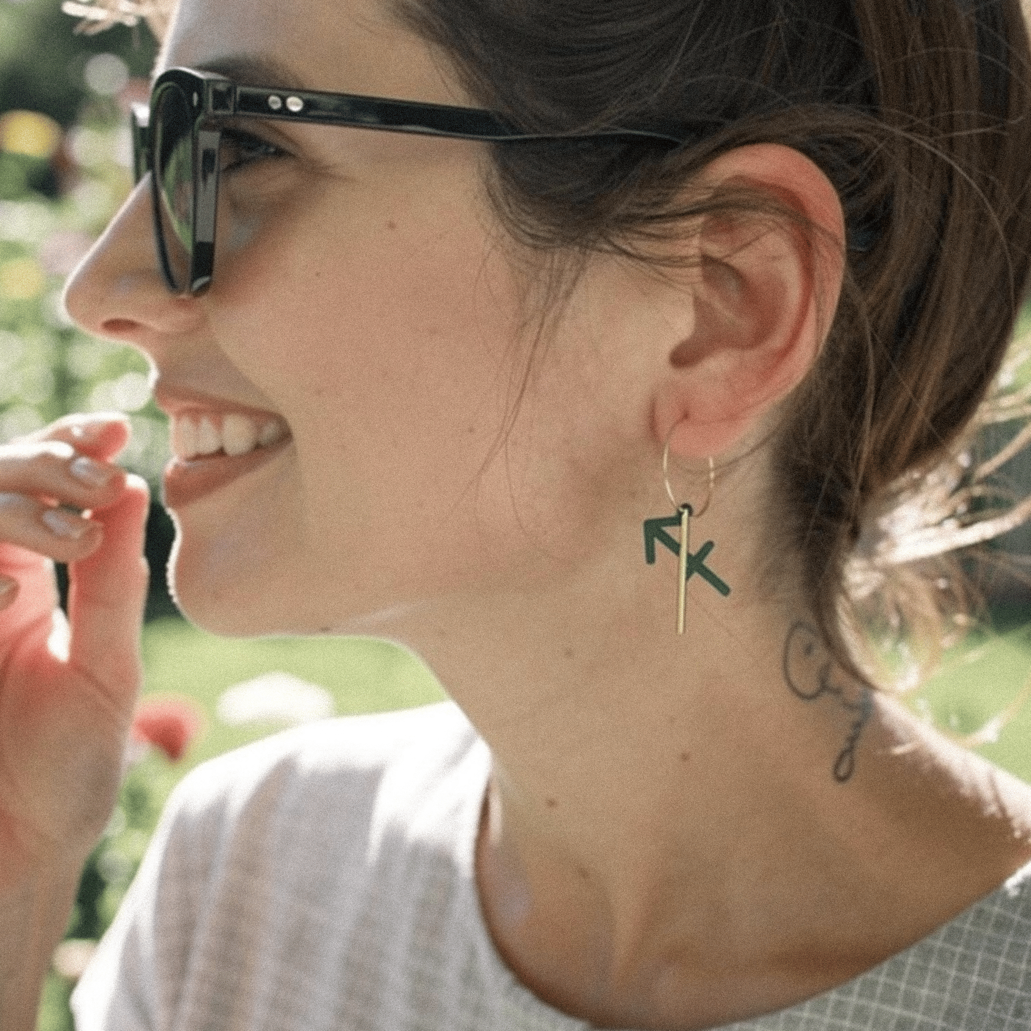 Boucle d’oreille Sagittaire portée par une femme, créole dépareillée avec signe astrologique.