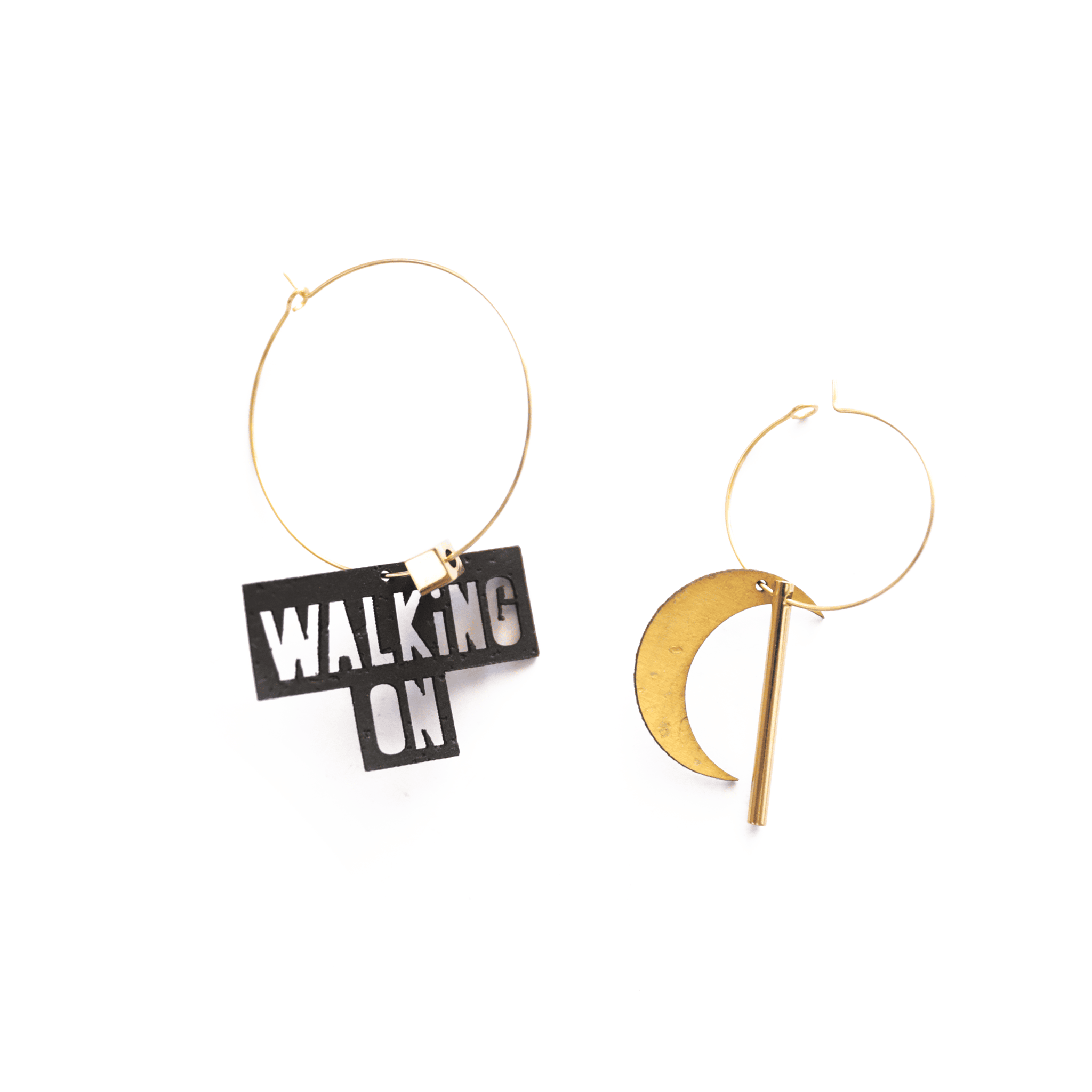 Boucles d’oreilles asymétriques inspirées de la chanson "Walking on the Moon" : une créole dorée avec breloque noire "WALKING ON" et une autre avec lune jaune. Bijoux personnalisables fabriqués en France.
