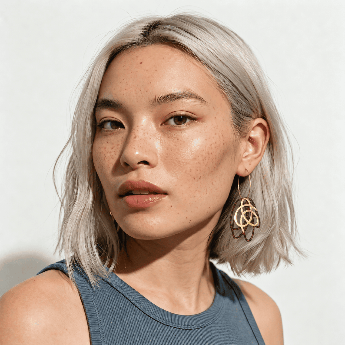 Boucles d'oreilles dépareillées Jane & Tarzan sur femme asiatique cheveux blonds— liège ajouré léopard bordeaux et nœud doré sur créoles, chainette pendante, Matcha Bijoux