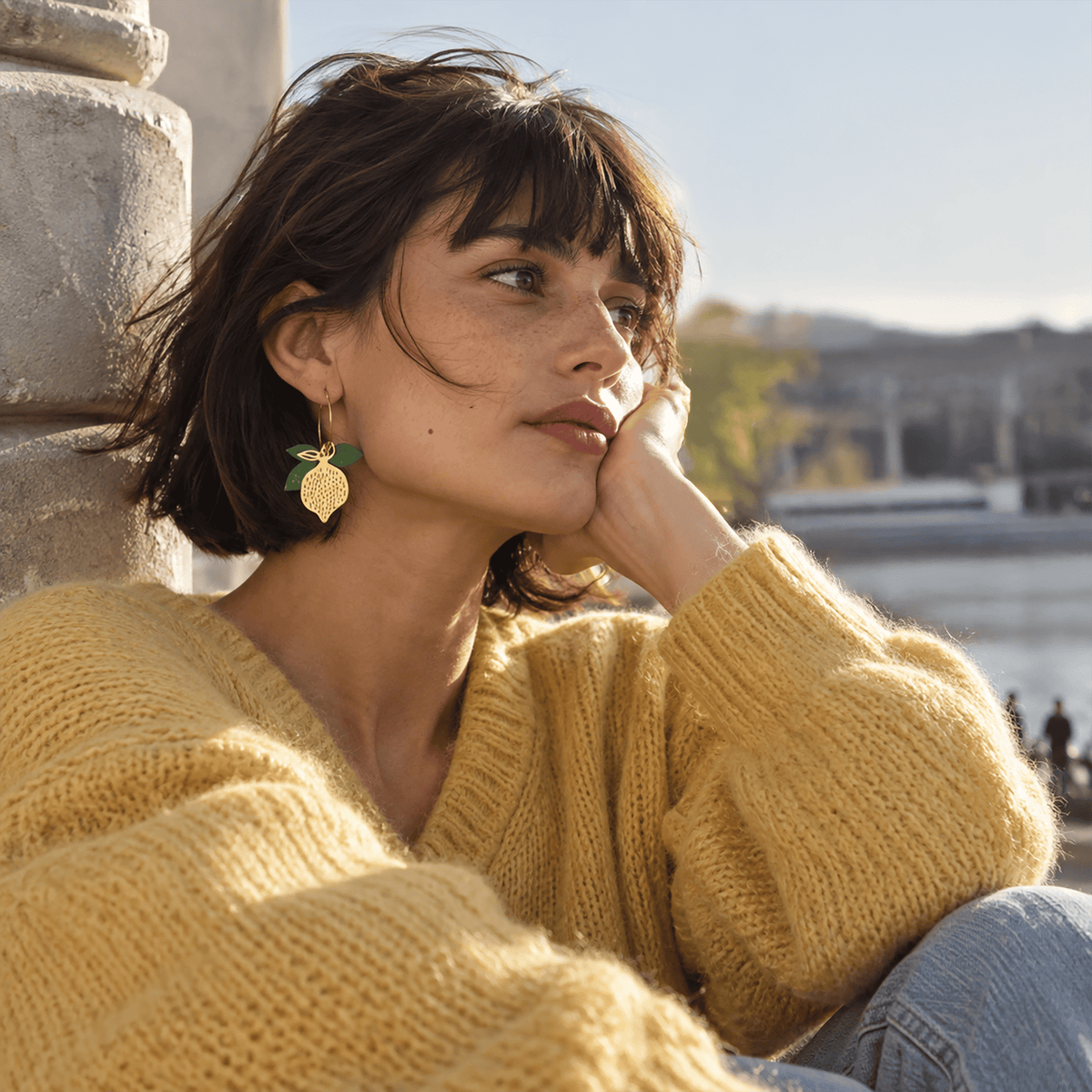 Boucles d'oreilles dépareillées Limon & Cello portées — citron en acier inox doré et feuilles en liège vert, faites main en France
