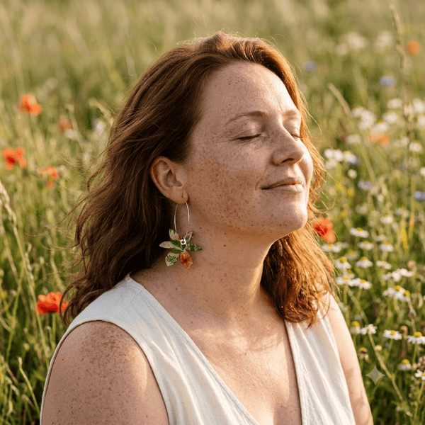 Boucles d'oreilles dépareillées Brangelina Champêtre portées — créoles liège imprimé floral Matcha Bijoux dans un champ de coquelicots