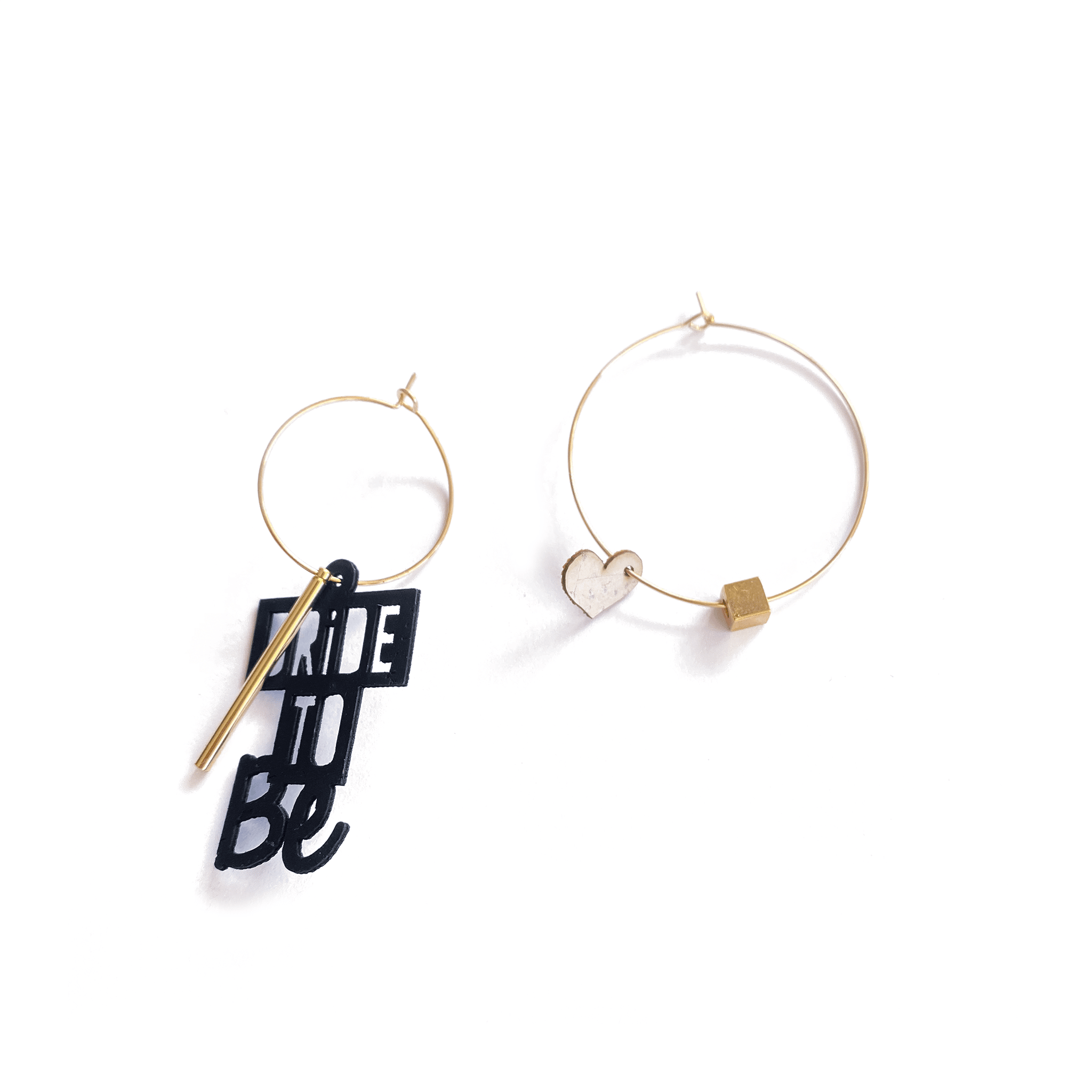 Boucles d'oreilles dépareillées Bride to Be Glam : créoles dorées charm texte noir et cœur cube doré, bijou EVJF mariée artisanal rock fait en France.