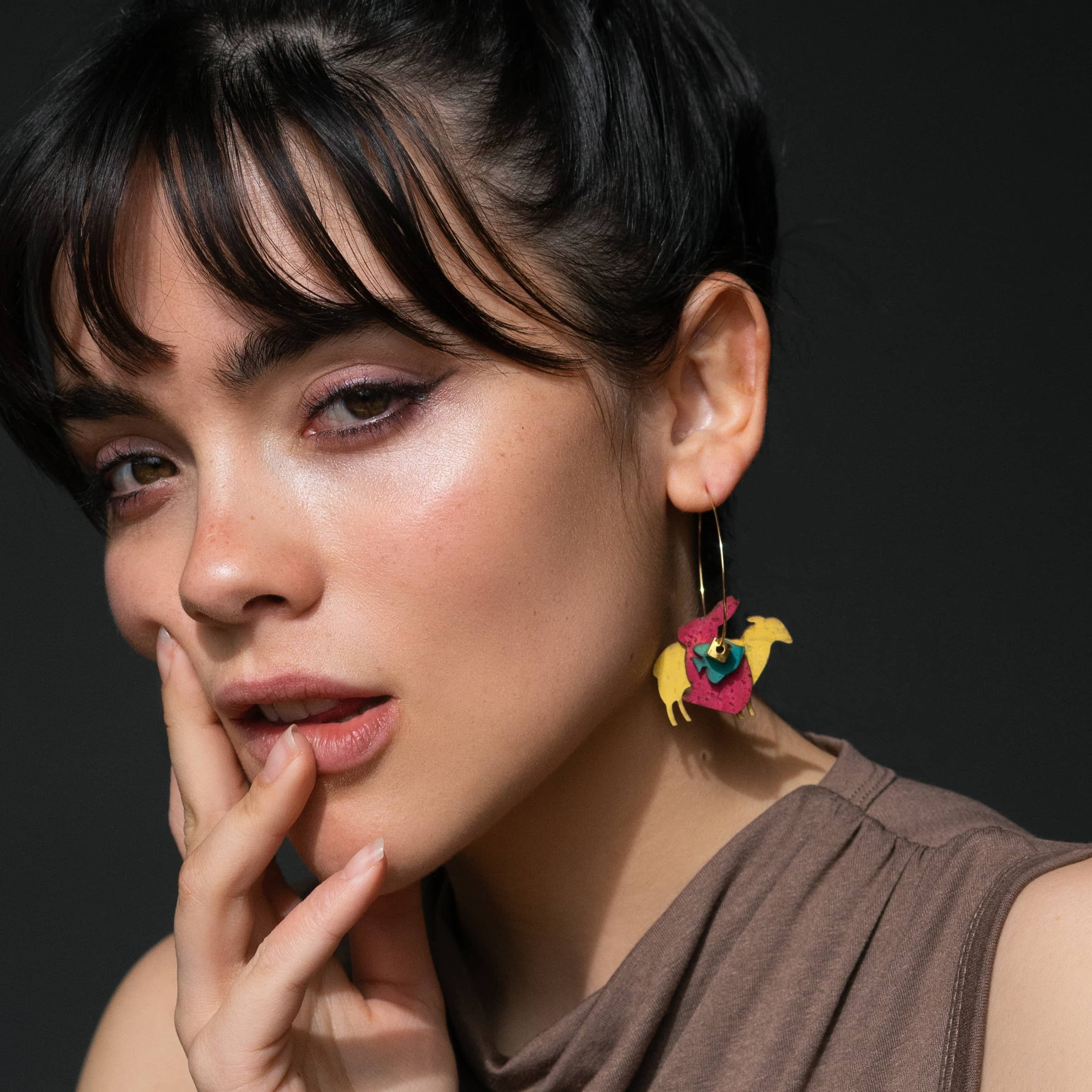 Créoles asymétriques Animal Rights vegan portées par un modèle femme, boucles d’oreilles dépareillées écoresponsables fabriquées en France.