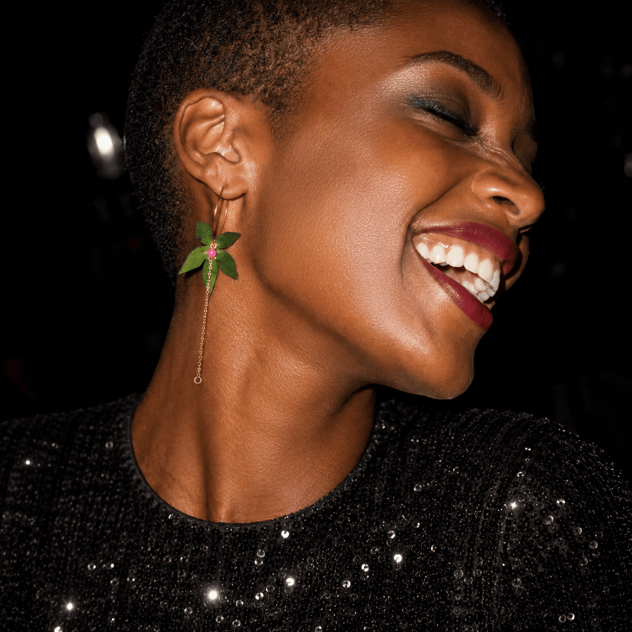 Boucles d'oreilles dépareillées Shiva & Vandana portées : créole dorée feuilles vertes et chainette, bijou nature rock artisanal fait en France.