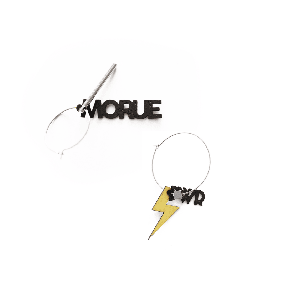 Paire de créoles asymétriques en finition argentée : l’une avec le mot "MORUE" en lettres noires et une barre métallique, l’autre avec un éclair doré et les lettres "PWR". Bijoux audacieux, vegan, fabriqués en France.