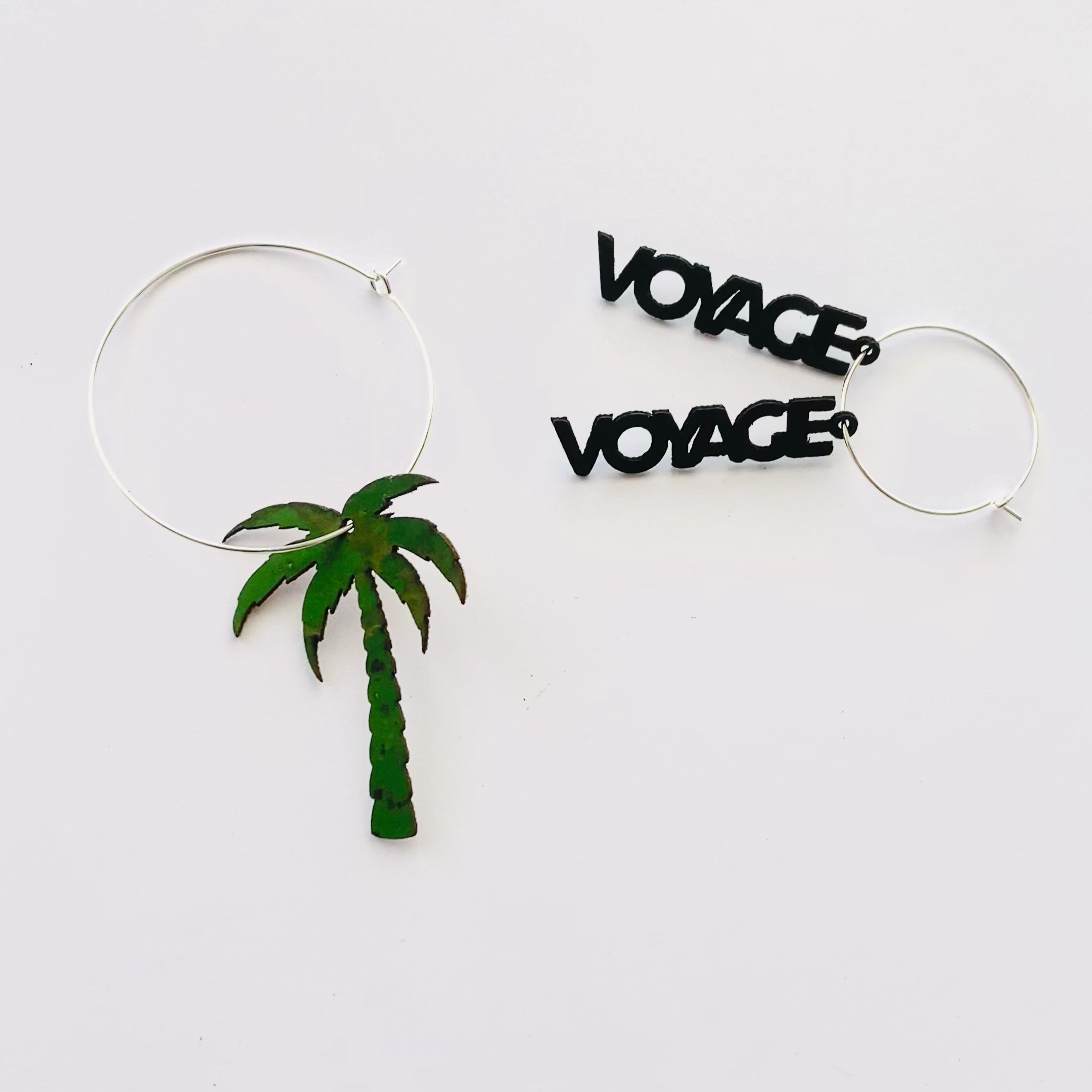 Vidéo boucles d'oreilles dépareillées Voyage Voyage — palmier liège vert et message noir créoles asymétriques Matcha Bijoux